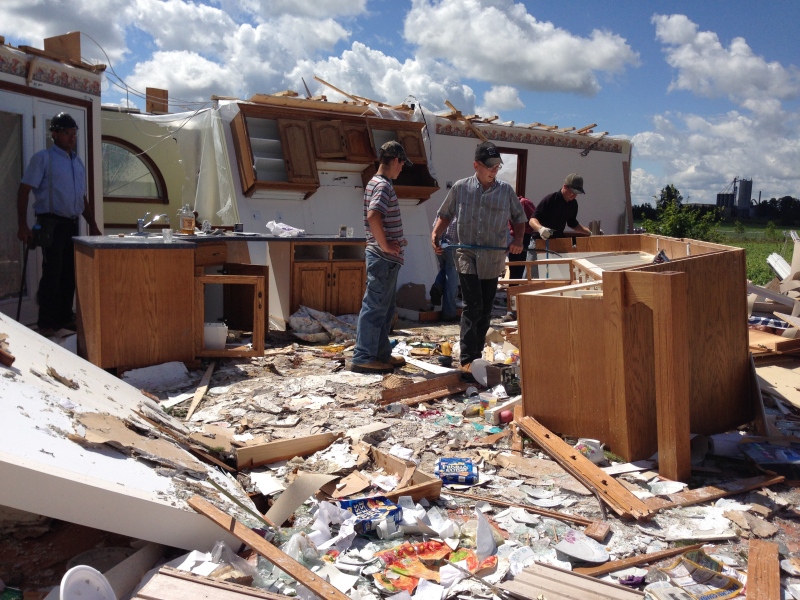 Neighbours help clean up a home devastated by a tornado in Teviotdale on Monday August 3, 2015.