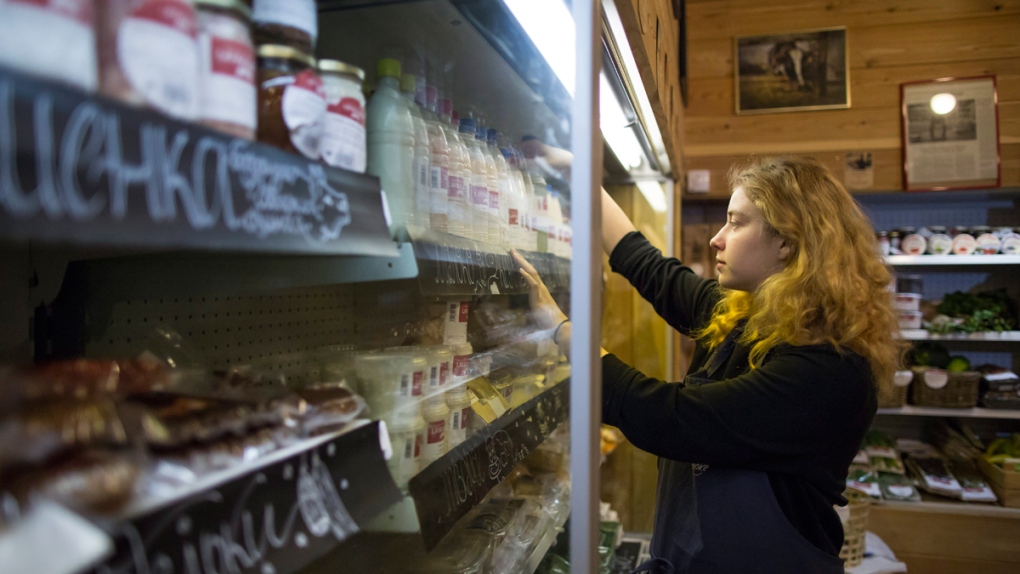 Stocking a shelf at a Moscow's farmers' food store