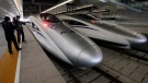 In this Oct. 26, 2010 file photo, a journalist photographs bullet trains of a new high-speed railway linking Shanghai and Hangzhou in Shanghai before the start of the service. (AP / Eugene Hoshiko, File)