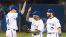 Toronto Blue Jays players Kevin Pillar and Ben Revere congratulate pitcher Roberto Osuna on the save after they defeated the Oakland Athletics 4-2 in their AL baseball game in Toronto on Tuesday August 11, 2015. The Blue Jays defeated the Athletics 4-2. (THE CANADIAN PRESS/Fred Thornhill)