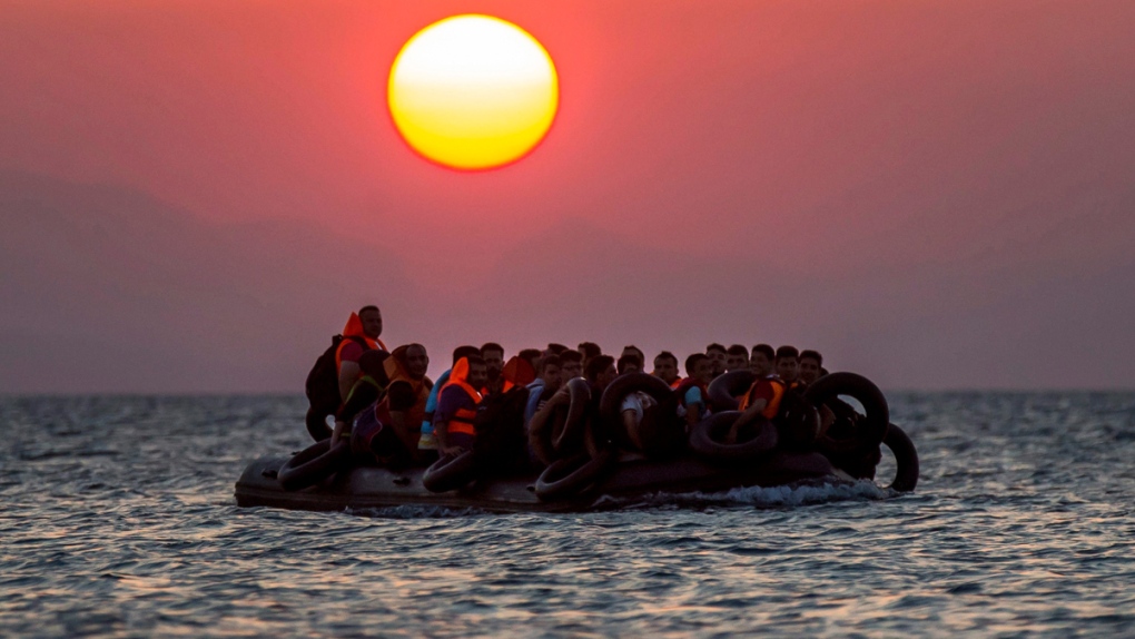 Migrants on a dinghy arrive at Kos, Greece