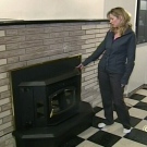 Angela Dupont looks at the wood pellet stove she recently bought with her boyfriend. The couple is now having a difficult time finding wood pellets needed to fuel the stove.