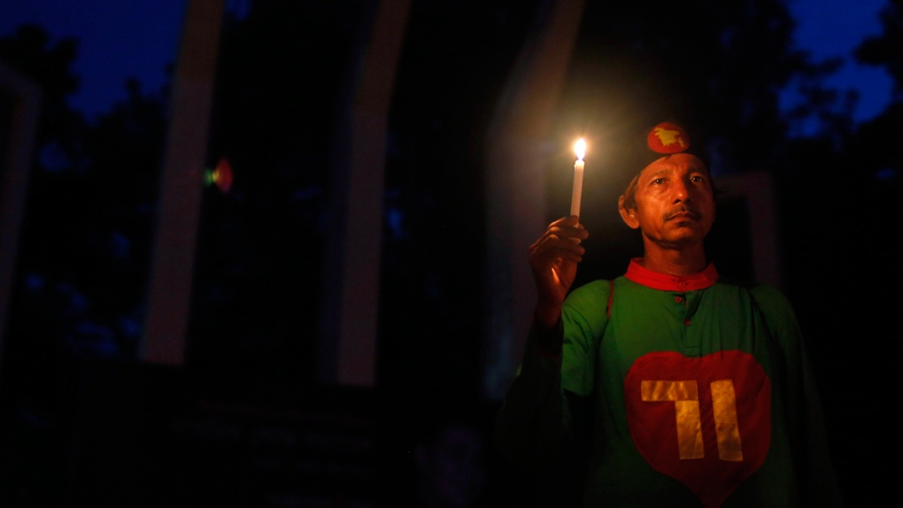 Bangladeshi activist holds a candle during a prote