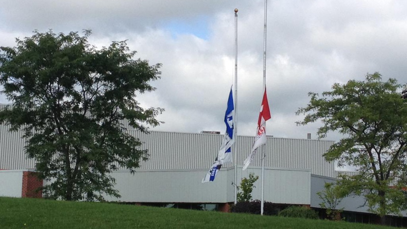 Flags fly at half-mast outside Polycon Industries on Friday, Aug. 28, 2015. (Nadia Matos / CTV Kitchener)