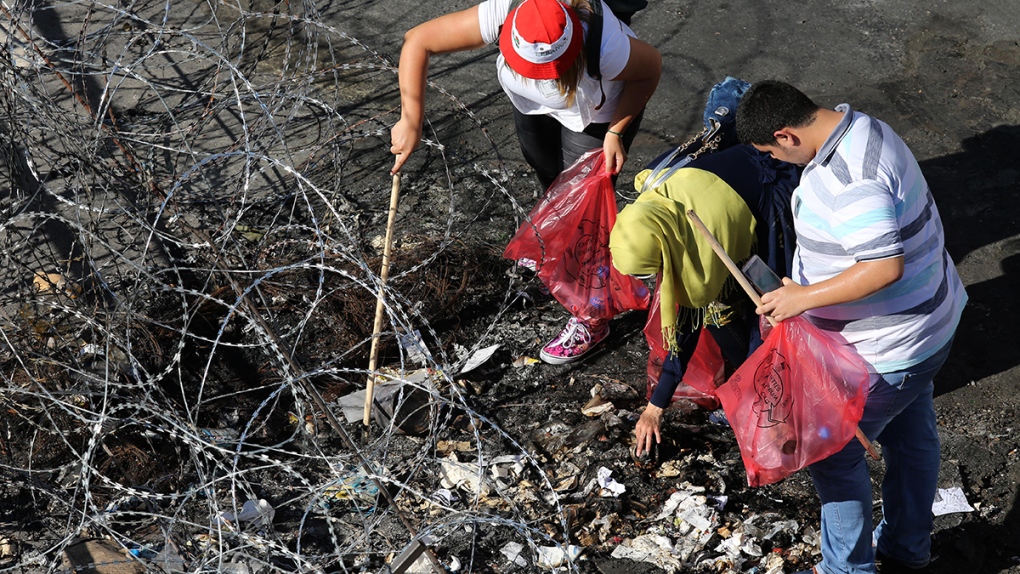 Lebanese anti-government protesters pick up trash