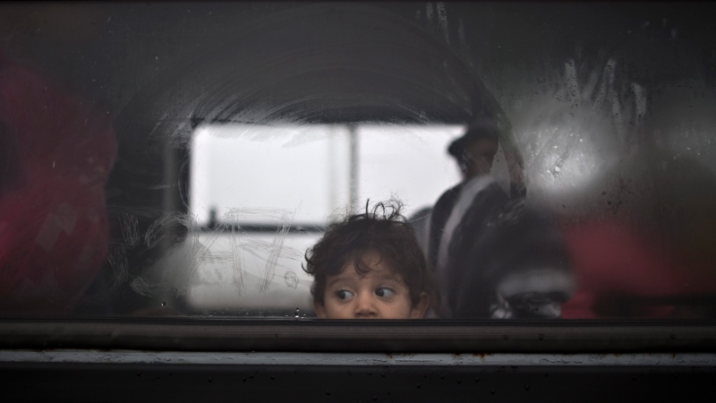 A Syrian refugee child looks out of a bus that will take him and his family to the center for asylum seekers near Roszke, southern Hungary, Friday, Sept. 11, 2015.  (AP / Muhammed Muheisen)