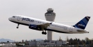 In this April 23, 2013, file photo, a JetBlue plane takes off in view of the air traffic control tower at Seattle-Tacoma International Airport, in Seattle. (Elaine Thompson, File/AP Photo)