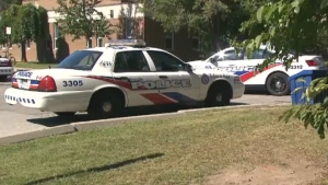 Police vehicles are parked outside George S. Henry Academy in Toronto on Thursday, Sept. 24, 2015. 