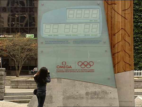 A woman takes a picture of the stalled Olympic countdown clock outside of the Vancouver Art Gallery on November 27, 2008. 
