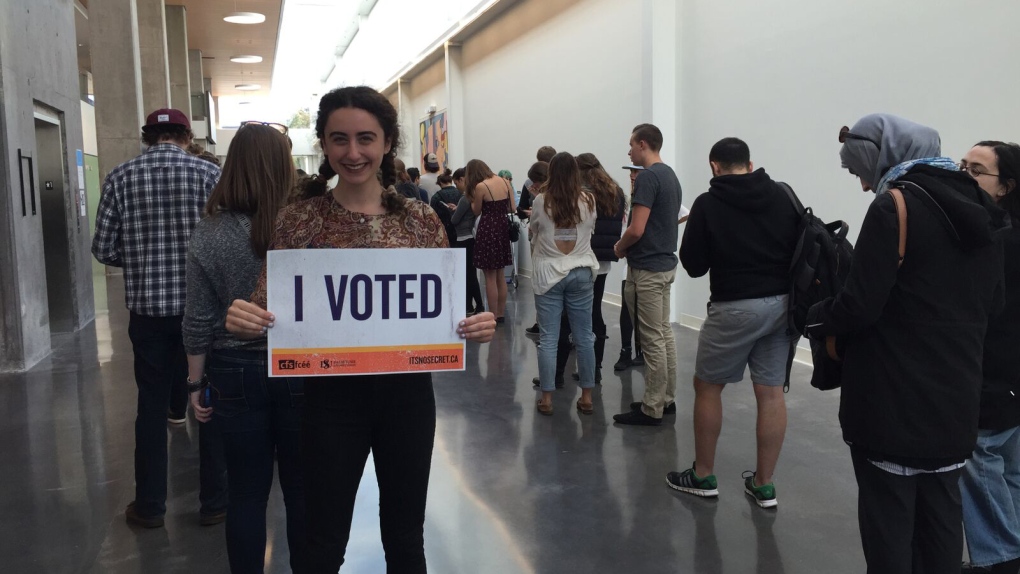 Student holds an ' I voted' sign. 