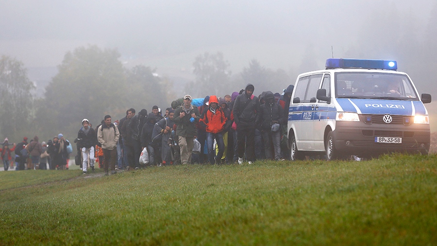 officers guide a group of migrants