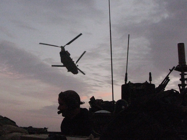 A Chinook helicopter carrying Royal Marines flies over a Canadian armoured vehicle at twilight on Thursday, Nov. 27, 2008. (Bill Graveland / THE CANADIAN PRESS)