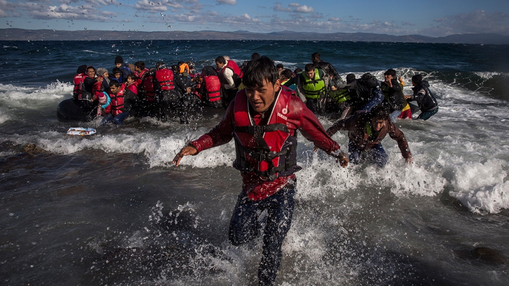 Afghan migrants disembark in the Aegean Sea