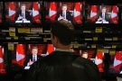 A shopper watches as Prime Minister Stephen Harper addresses the country on television screens at an electronics store in Vancouver, B.C., on Wednesday December 3, 2008. (Darryl Dyck / THE CANADIAN PRESS)