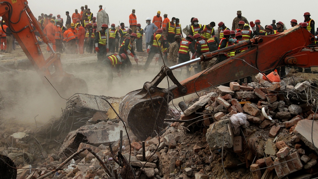 Excavators dig rubble after factory collapse