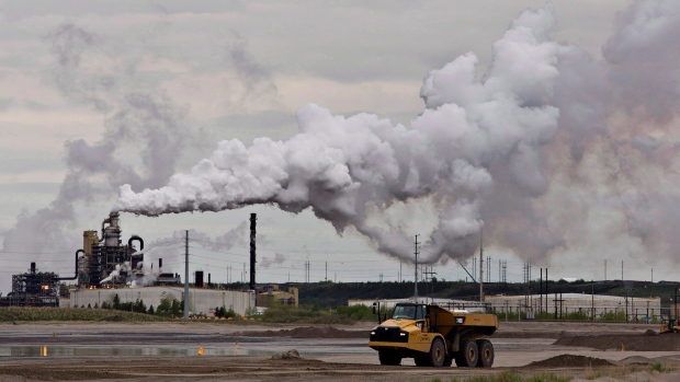 A dump truck works near the Syncrude oil sands extraction facility near the city of Fort McMurray, Alberta on Sunday June 1, 2014. (THE CANADIAN PRESS/Jason Franson)