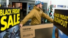 A customer carries a large TV to the checkout at a Best Buy store on Black Friday, shortly after the store's 6 a.m. opening in Ottawa on Friday, Nov. 27, 2015. (Justin Tang / THE CANADIAN PRESS)