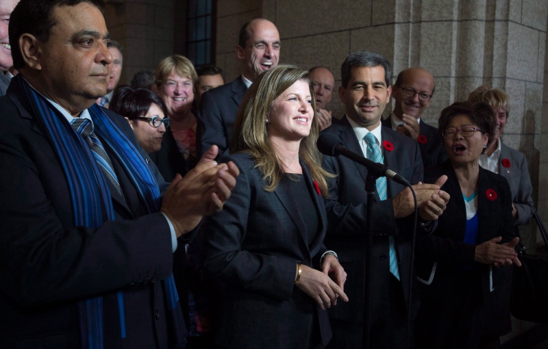 Surrounded by members of caucus, Rona Ambrose speaks after being named as the interim-leader of the Conservative party following a caucus meeting in Ottawa on Thursday November 5, 2015. (Adrian Wyld / THE CANADIAN PRESS) 