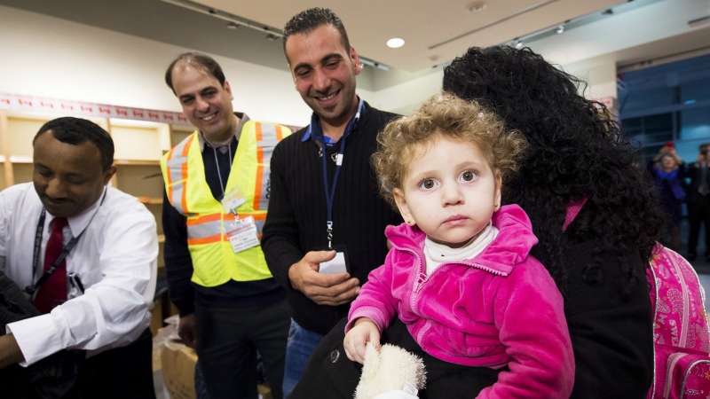 In this file photo, a child arrives with her family, refugees fleeing the Syrian civil war, at Pearson International airport, in Toronto, on Friday, Dec. 11, 2015. (Nathan Denette / THE CANADIAN PRESS)