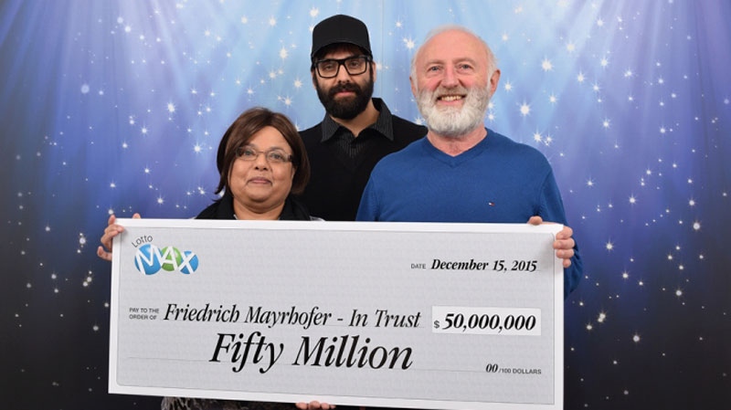 Friedrich and Annand Mayrhofer and their son Eric pose with their oversized cheque for $50 million. Dec. 15, 2015. (Handout)
