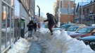 Man maneuvers snowbank in downtown Ottawa.