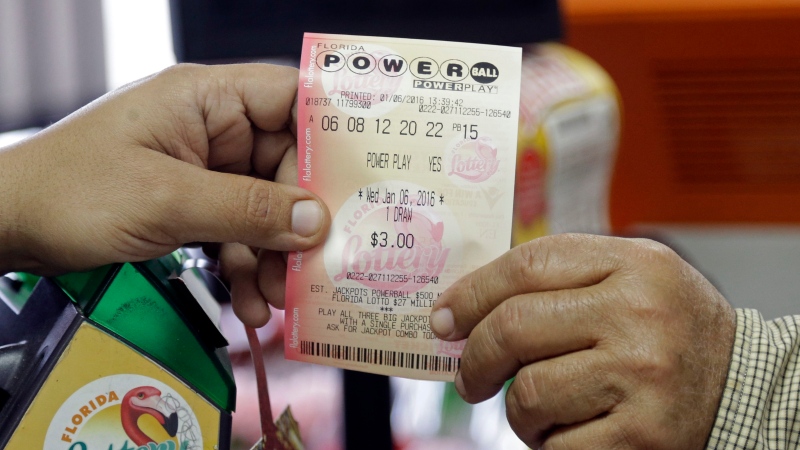 FILE - A clerk hands over a Powerball ticket to a customer, Wednesday, Jan. 6, 2016, at a local grocery store in Hialeah, Fla. (AP / Alan Diaz)
