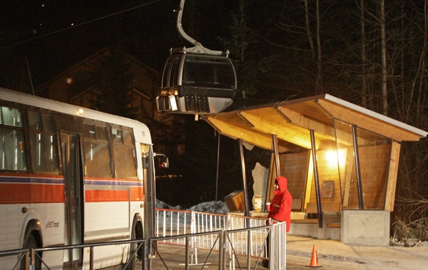 A security guard stands by as a gondola car rests on top of a bus shelter after a gondola support tower partially collapsed at Blackcomb Mountain in Whistler, B.C., on Tuesday, Dec. 16, 2008. (Darryl Dyck / THE CANADIAN PRESS)