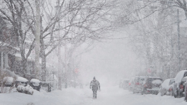 A man walks up the middle of a street in Toronto as a snow storm hits with strong winds and heavy snow on Monday, February 2, 2015. THE CANADIAN PRESS/Darren Calabrese