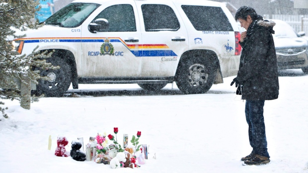 A resident of La Loche, Sask., pays his respects to the victims of a Friday school shooting on on Saturday, Jan. 23, 2016. (Jason Franson /THE CANADIAN PRESS)