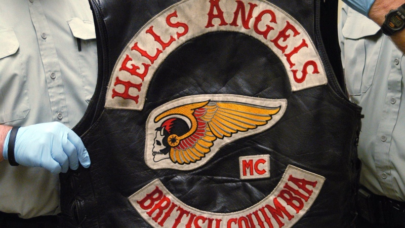 In this file photo, RCMP officers display a Hells Angels vest in Richmond, B.C. in this handout photo. (CP PHOTO / HO / BC RCMP)