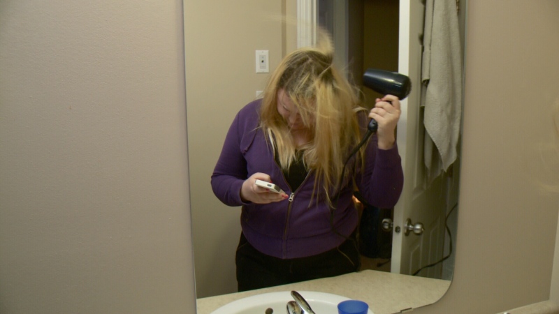 Chantel Menard drying her hair while texting.