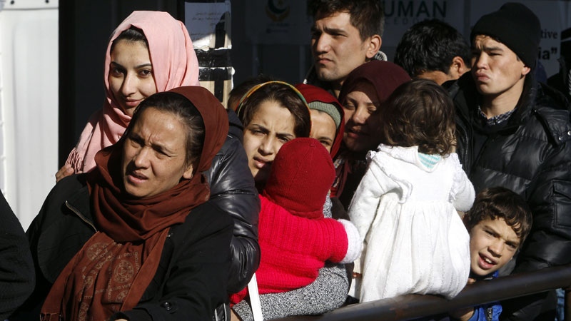 Afghan refugees stand in a queue in Macedonia