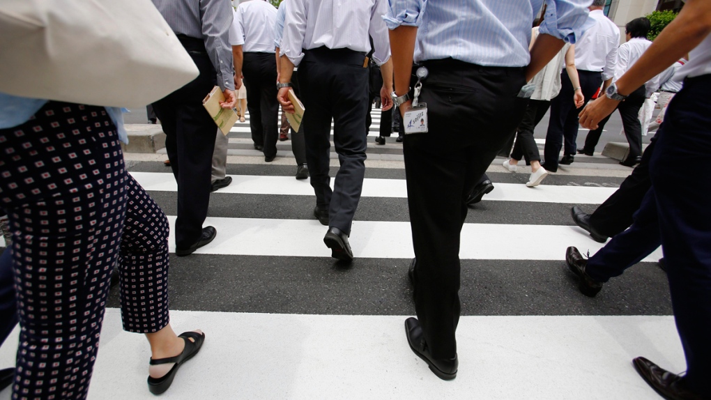Office workers walk in Tokyo, Japan