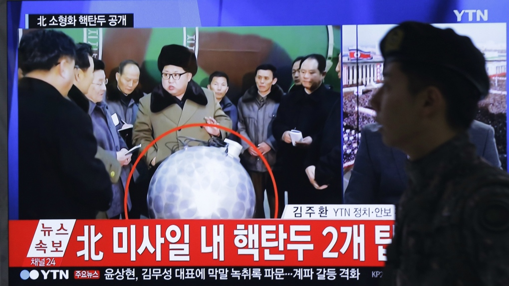 Kim Jong Un poses beside purported warhead