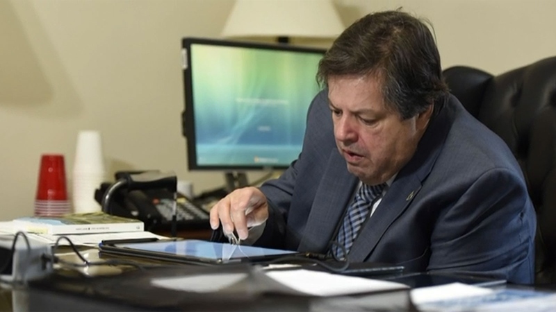 Ottawa-Vanier MP Mauril Belanger uses an iPad to speak with reporters.