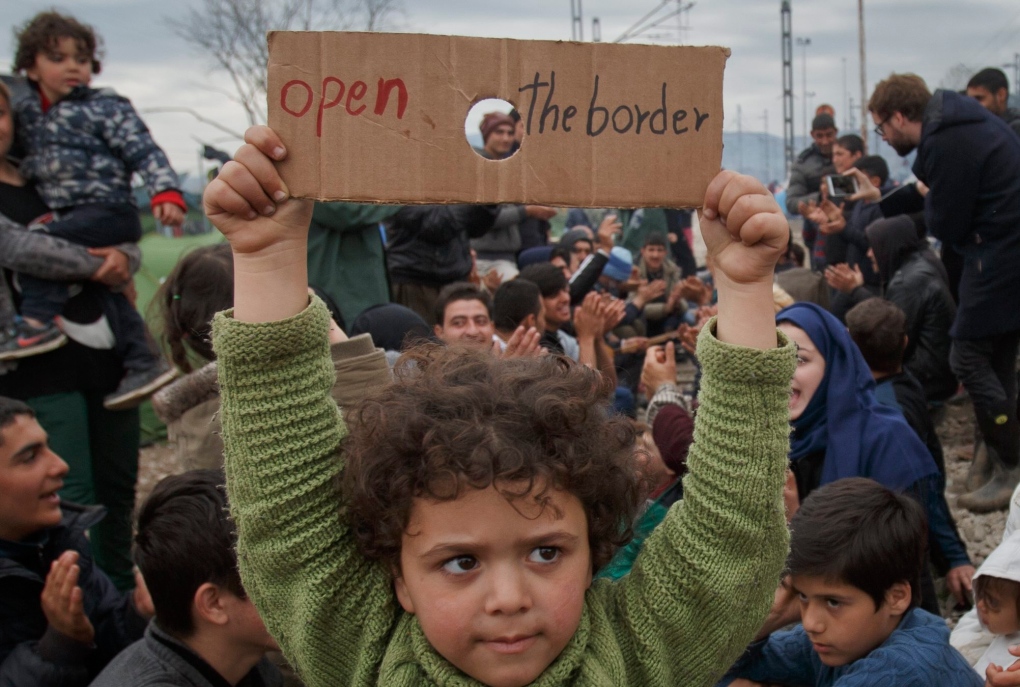 Child holds sign during migrant protests