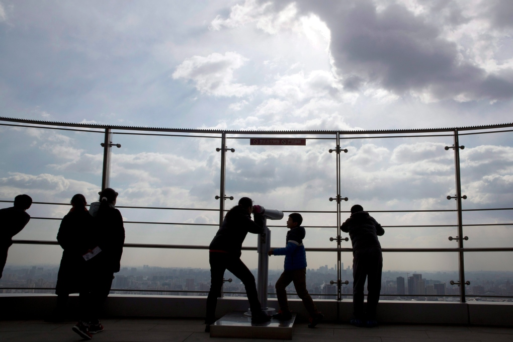 Visitors look over the skyline of Chinese capital