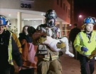 A fireman carries a child to safety after a fire at an apartment building in Richmond Hill.