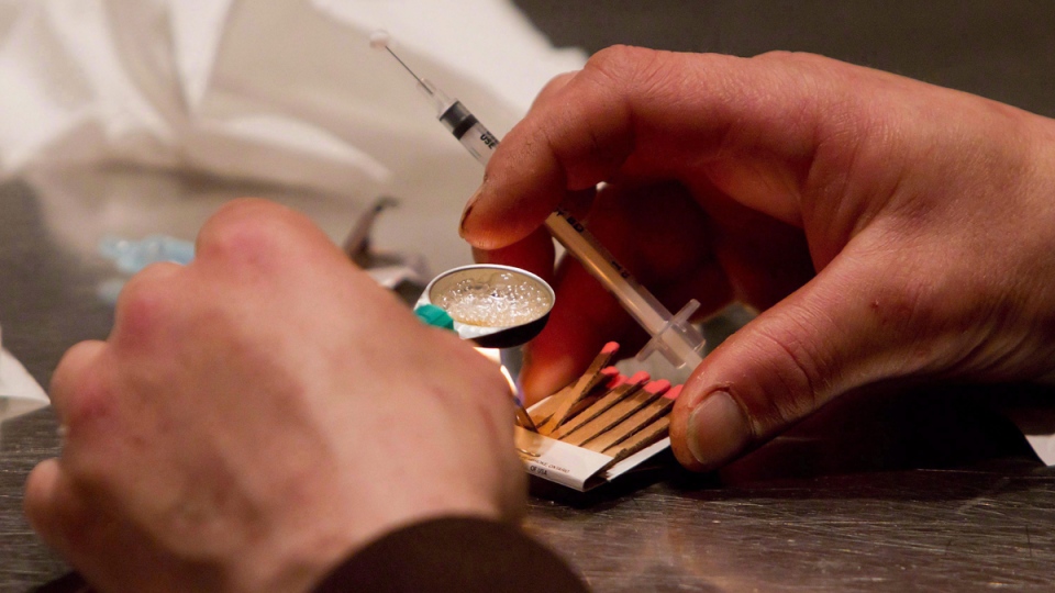 A man prepares heroin to be injected