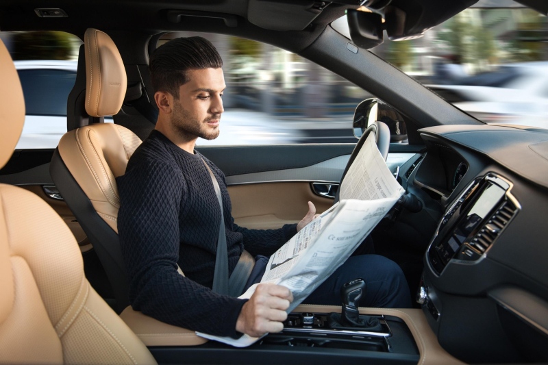 A man reads the newspaper in this concept photo for a driverless car. (Volvo / Relaxnews)