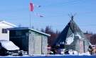A tattered Canadian flag flies over a building in Attawapiskat, Ont., on Nov. 29, 2011. (The Canadian Press/Adrian Wyld)