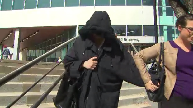 A hooded Andrea Giesbrecht is led away from the Law Courts Building during her trial several months ago. (File image)