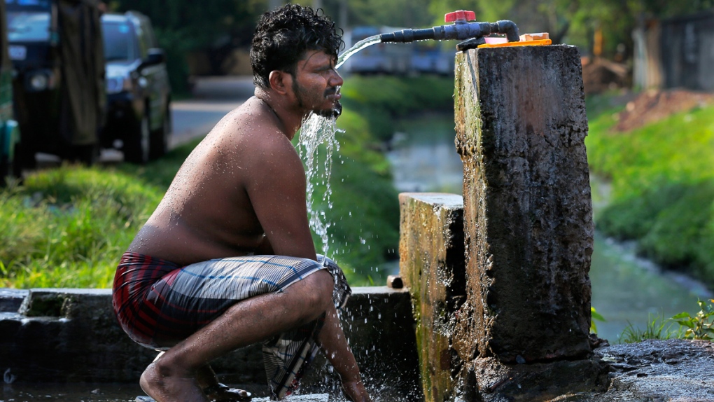 Taking a bath from a roadside tap in Colombo