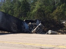 A burnt transport truck rests in a ditch off highway 17 after a fatal crash 