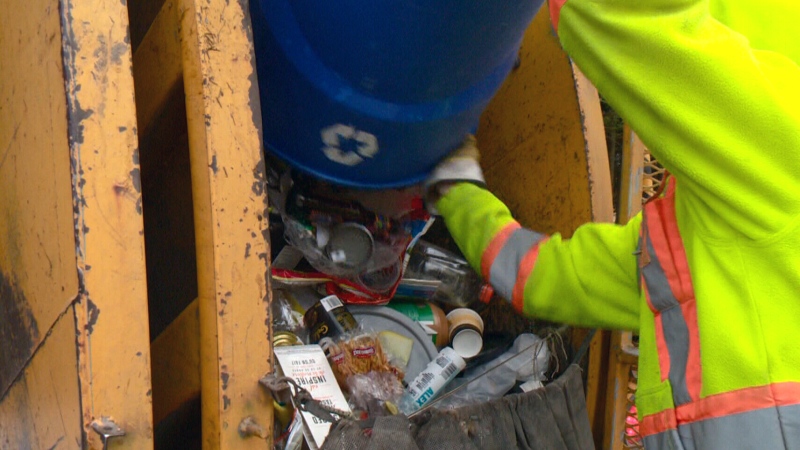 A collector empties a recycling bin in Ottawa. 