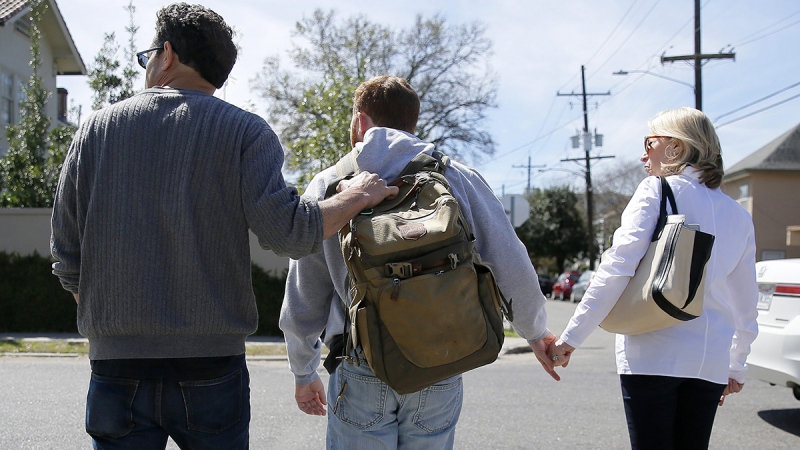 Sam Alexander and Ellen Schneider help their son, Ben, cross a street on their way to lunch in New Orleans. When Ben was about 2 1/2 he was diagnosed with autism. (AP / Jonathan Bachman)