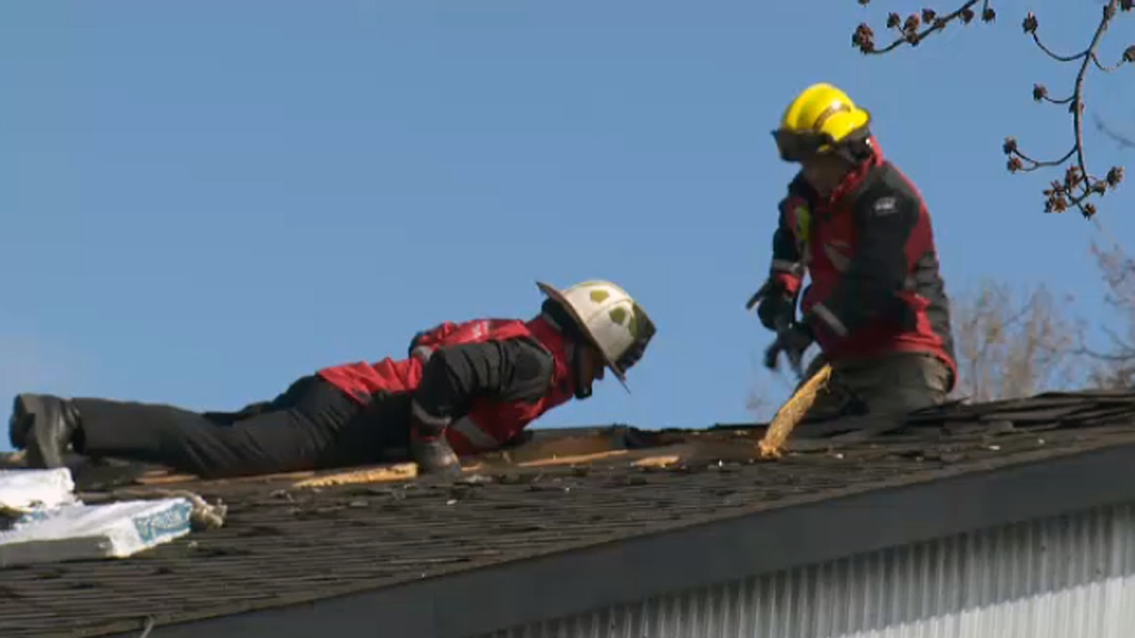 Safety crews inspect a roof damaged 