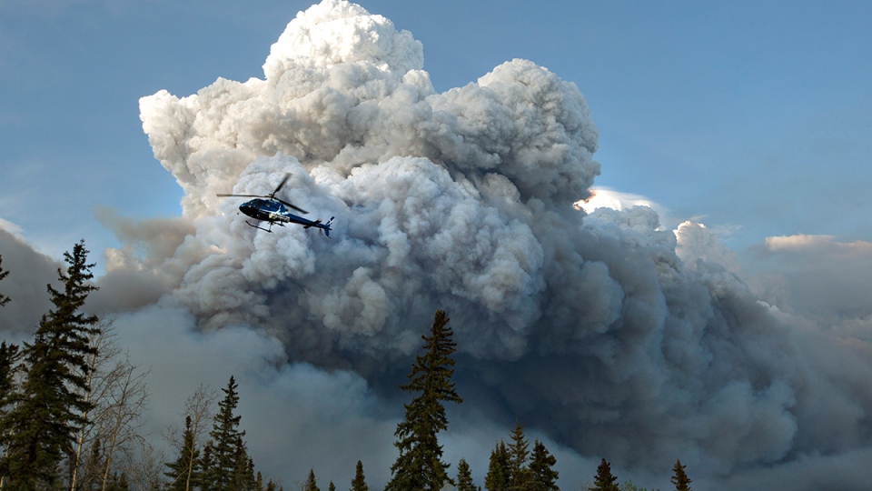 A helicopter flies past wildfire in Fort McMurray