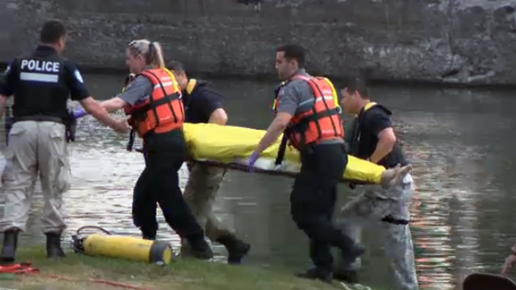 Rescue workers pull a body out of the Lachine Cana