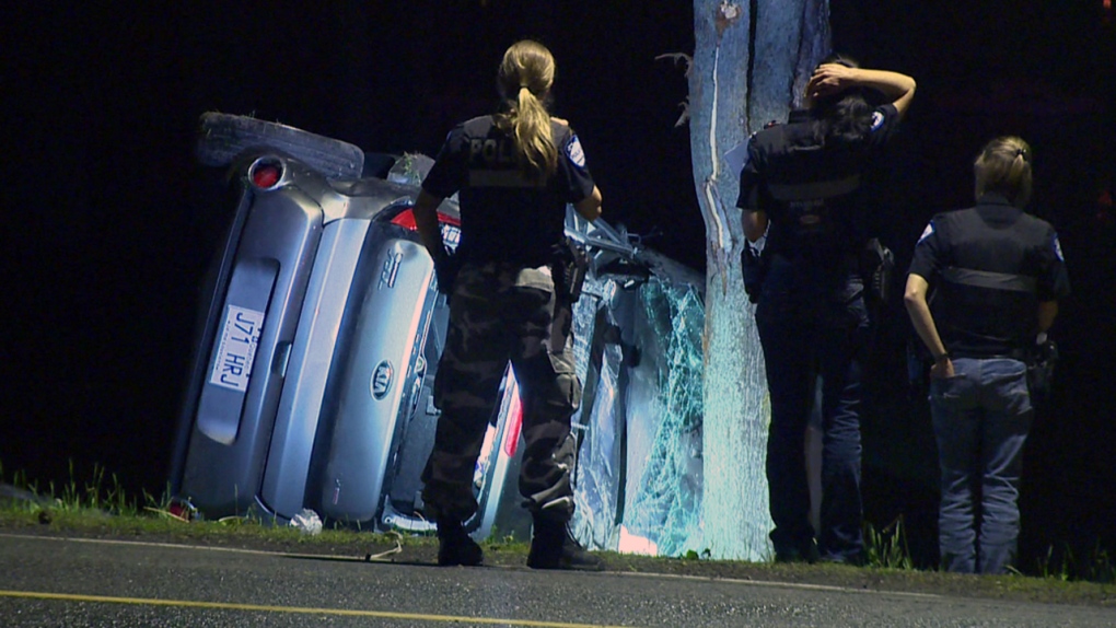 Police examine the wreckage of a Kia Soul